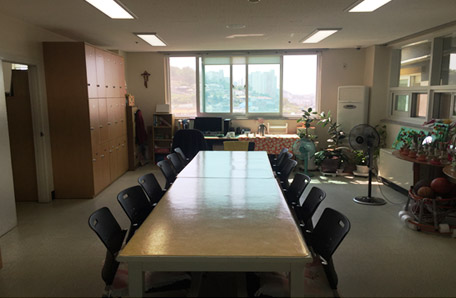 주간보호센터 사무실 내부에 테이블2개가 나란히 배치되어 있다