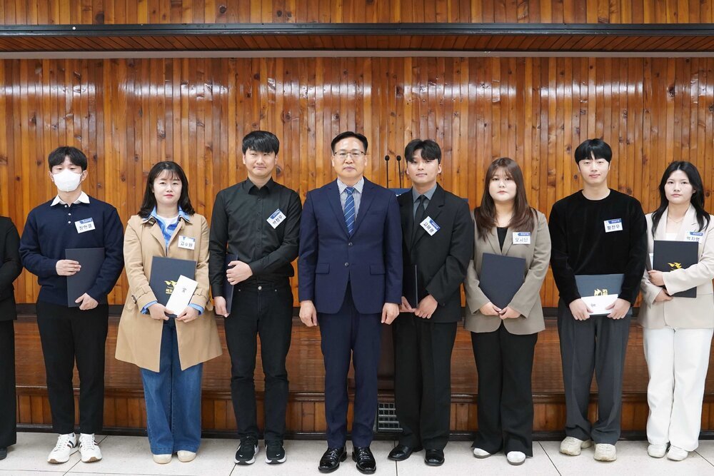 4월 정례조회 행사에서 정장을 입고 안경을 쓴 남성이 수상자들과 함께 기념촬영을 하고 있으며, 왼쪽부터 박신영, 정한결, 고주원, 박정우, 고해광, 오지인, 황찬우, 박지행, 김유라가 각각 상장을 들고 일렬로 서 있다.