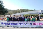 '3R 자원재활용품(헌옷) 모으기 경진대회' 현수막 뒤에서 옥암동 참가자들이 다 함께 파이팅을 외치는 모습이다. 배경의 숲과 파란 하늘 아래 행사가 진행되고 있다.