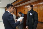 2월 정례조회에 정장을 입고 안경을 낀 남성이 머리를 뒤로 묶은 검은색아웃터에 검은색 목도리를 한 김보잉에게 패를 수여하고 있다.